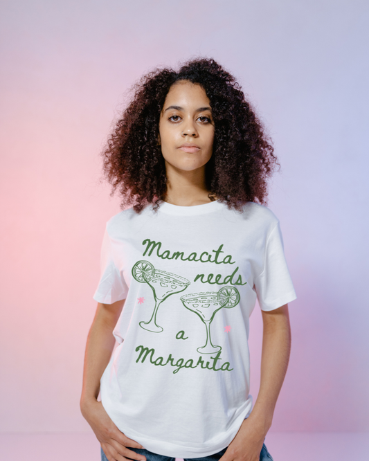 Person wearing a white t-shirt with 'Mamacita needs a Margarita' text and graphic on a gradient background